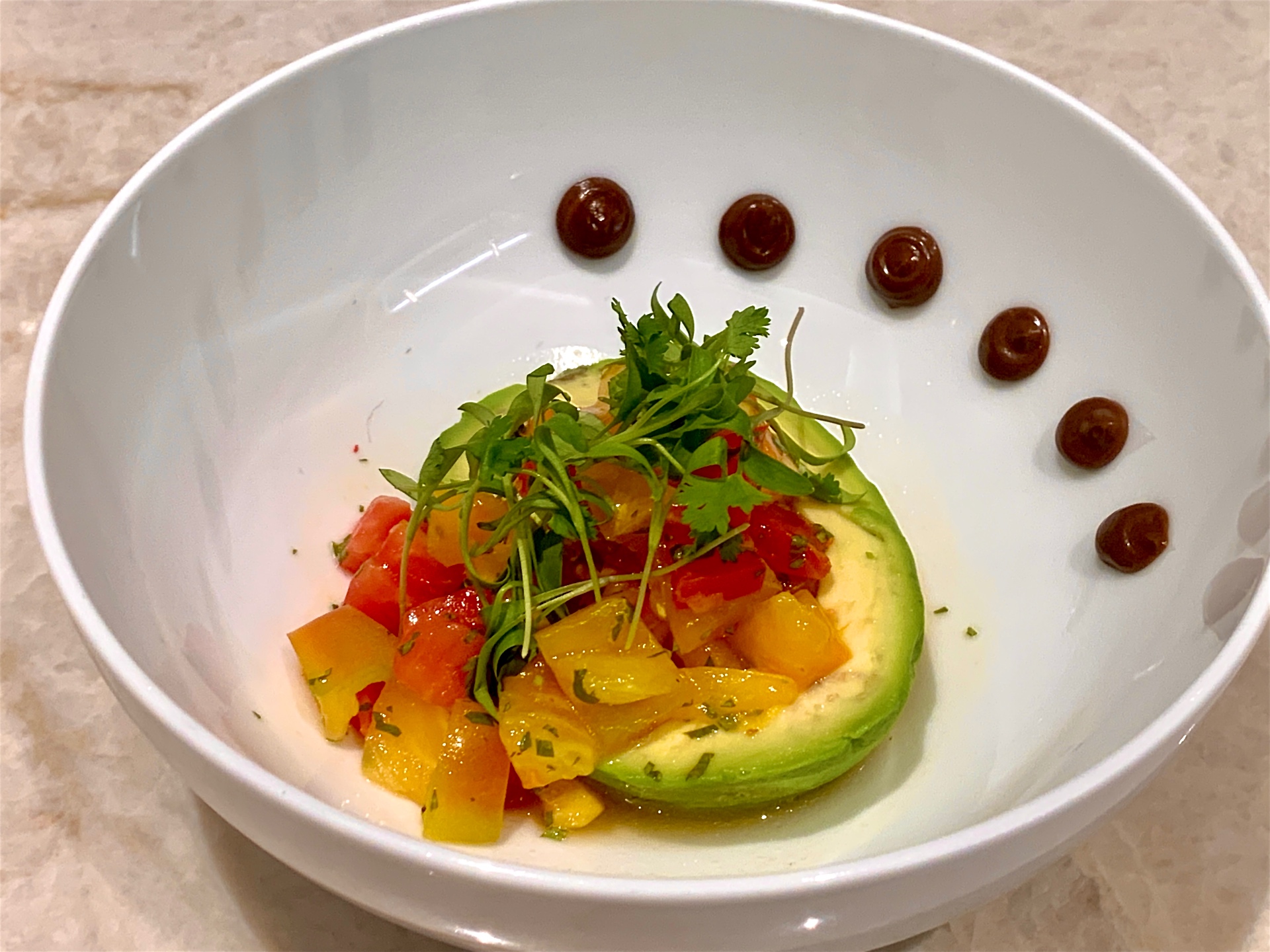 Plated avocado with heirloom tomato salsa, microgreens and balsamic dots
